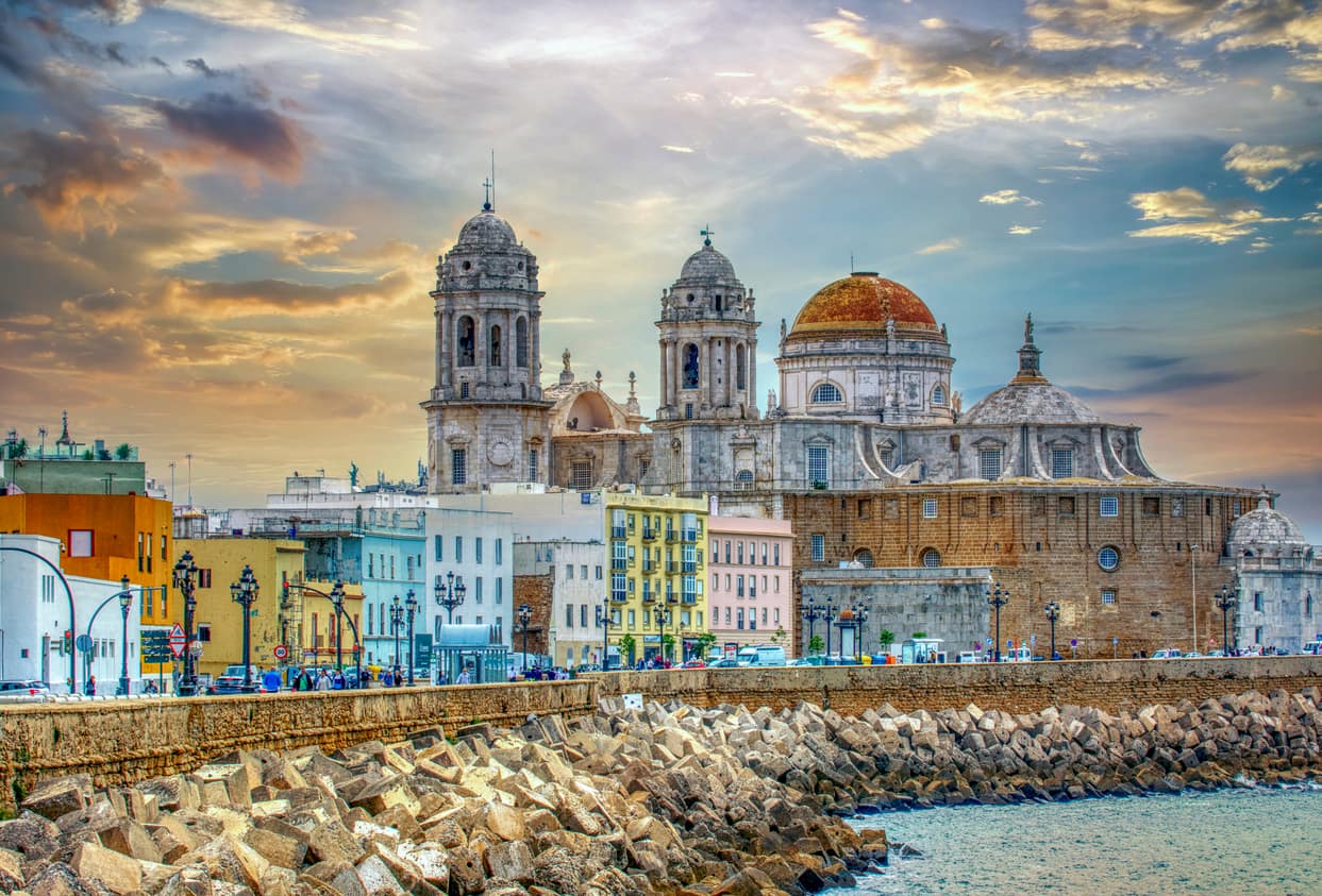Panoramic view of Cadiz at sunrise with its cathedral, Spain. Sunset view of Cadiz, Spain with ocean and old town - How to spend 3 days in Cadiz, Spain.