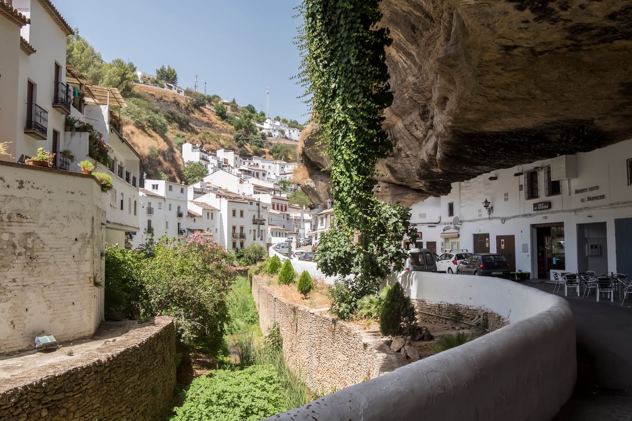 The white-washed village of Setenil de las Bodegas built into limestone overhangs, creating natural shade and time-drawn architecture