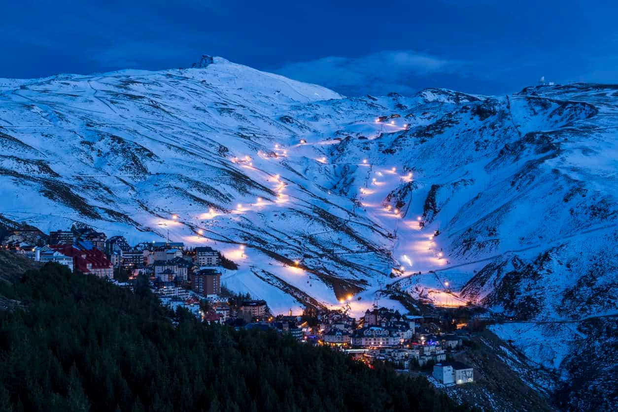 Lights at night in snowy hills in Sierra Nevada. Pradollano area, Sierra Nevada National Park, Granada, Andalusia, Spain. - Best Day Trips from Granada