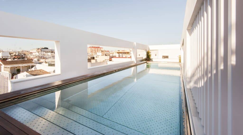 Modern, minimalist suite with tall ceilings and natural light at Mercer Hotel Seville
